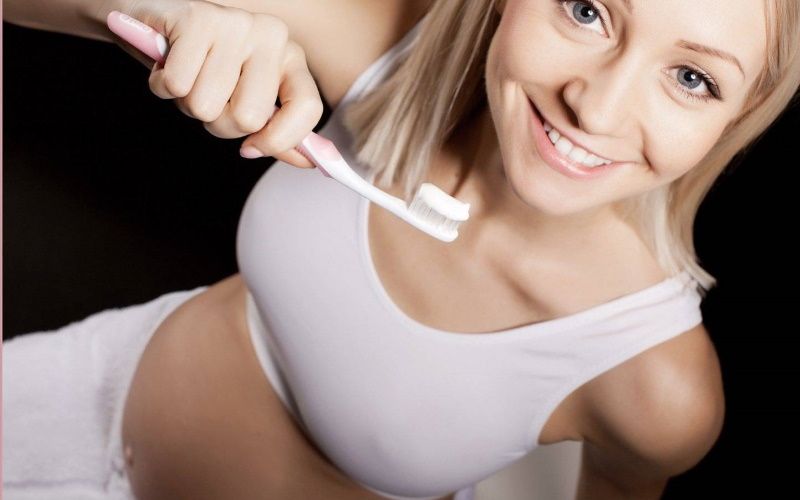 Беременная чистит зубы